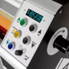 Tableau de commande de machine avec boutons colorés.