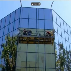 Nettoyeurs de vitres sur une façade en verre.