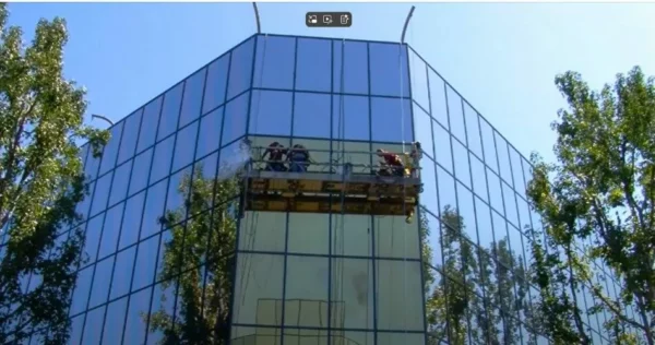 Nettoyeurs de vitres sur une façade en verre.