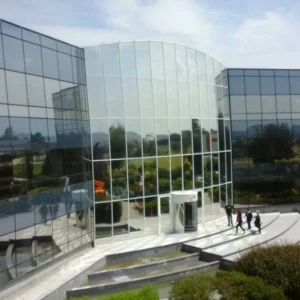 Bâtiment moderne avec façade en verre réfléchissante.