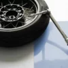 Roue de moto avec clé dynamométrique sur fond clair.