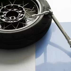 Roue de moto avec clé dynamométrique sur fond clair.