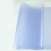 Rouleau de film transparent bleu sur fond clair.