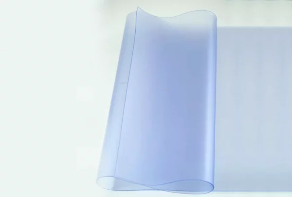 Rouleau de film transparent bleu sur fond clair.