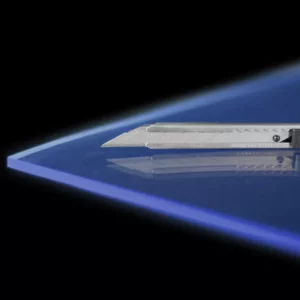 Cutter sur plaque bleue, fond noir.