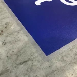 Sol en béton avec pancarte bleue.