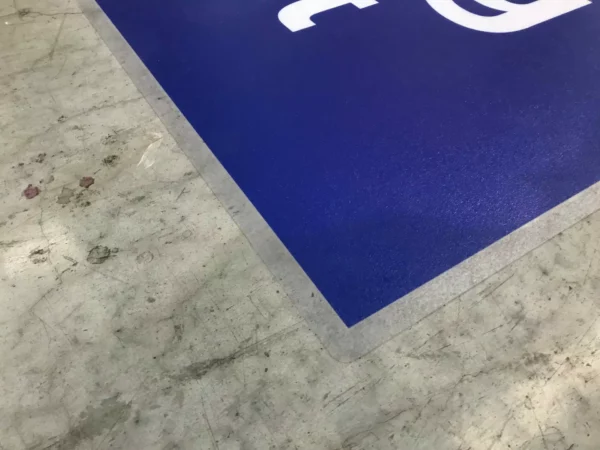 Sol en béton avec pancarte bleue.