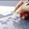 Main découpant pochoir de feuilles au cutter