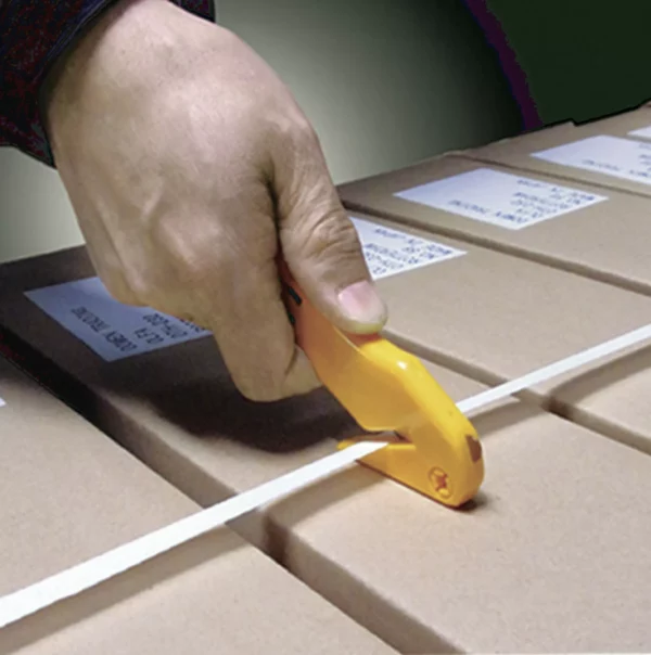 Main coupant un cerclage sur cartons