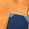 Coin d’un livre relié bleu sur bureau en bois