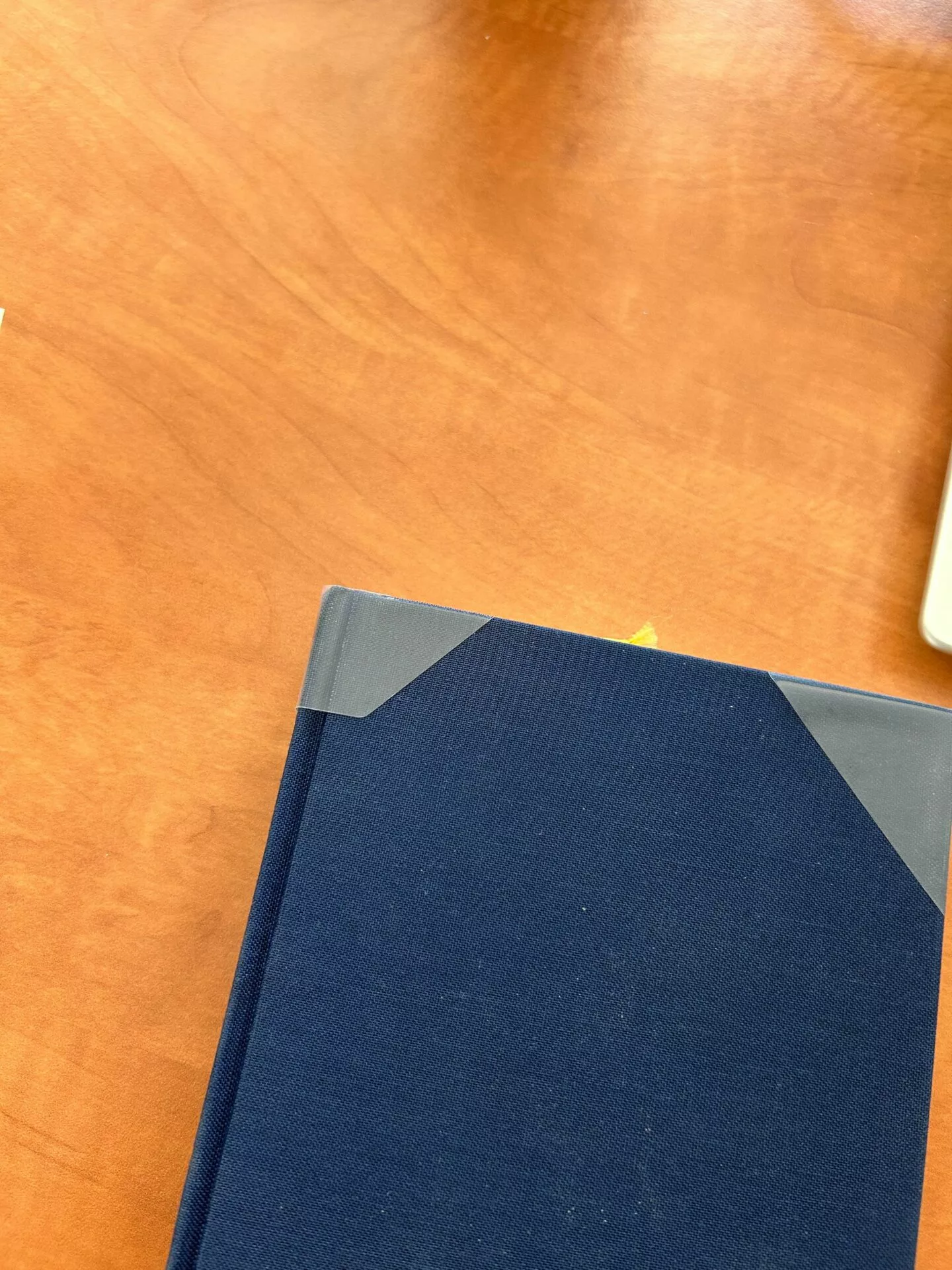 Coin d’un livre relié bleu sur bureau en bois